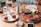 Elegant catering platter with Italian antipasti and fresh breads on a rustic wooden table.