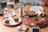 Elegant catering platter with Italian antipasti and fresh breads on a rustic wooden table.