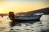 A small 60 cv boat gently floating on the calm waters of the Ebro Delta at sunset.