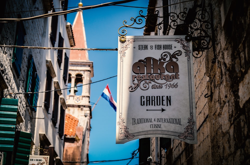 white and brown Alka Restaurant Garden signage