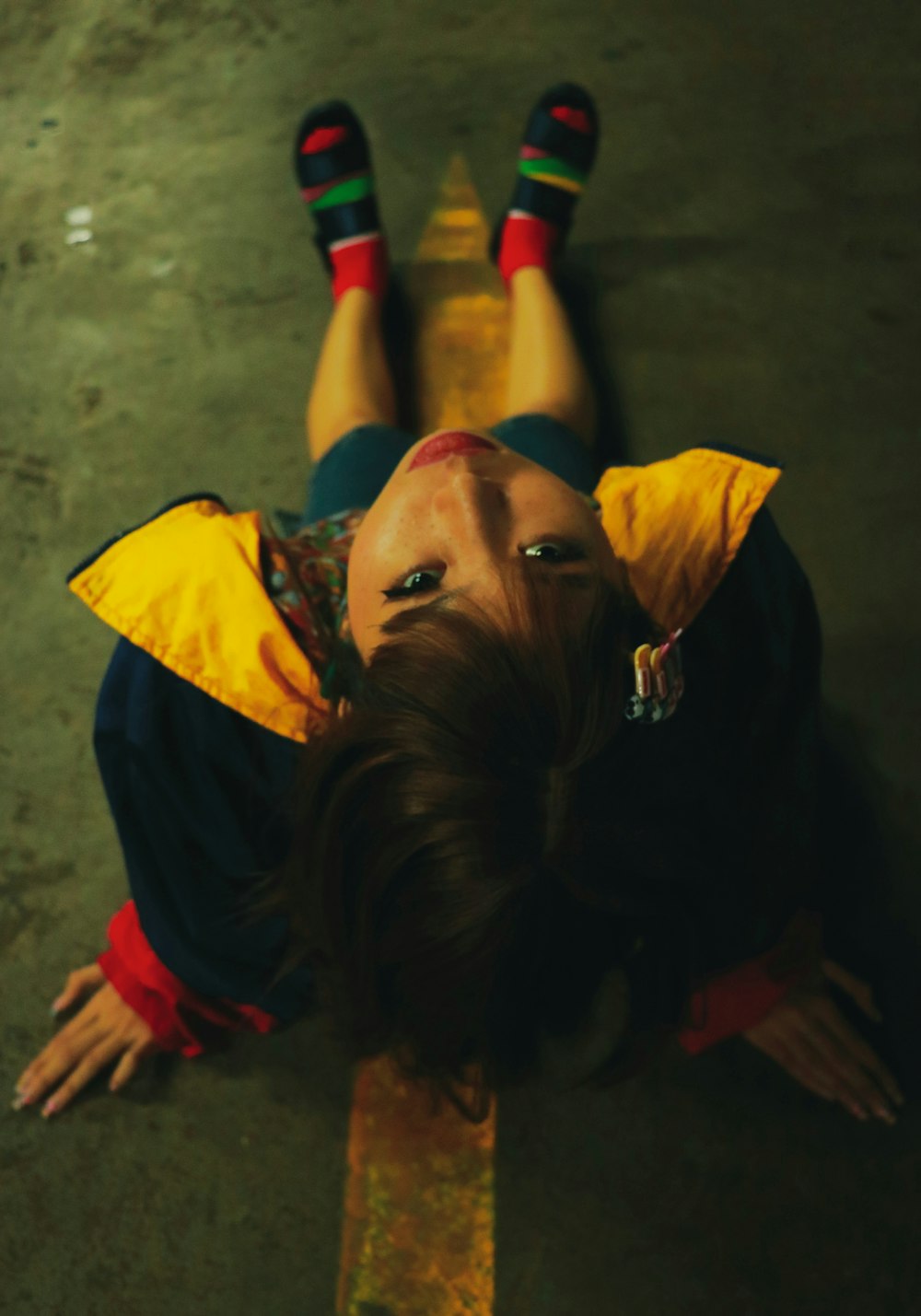 girl sitting on floor wearing yellow and black jacket