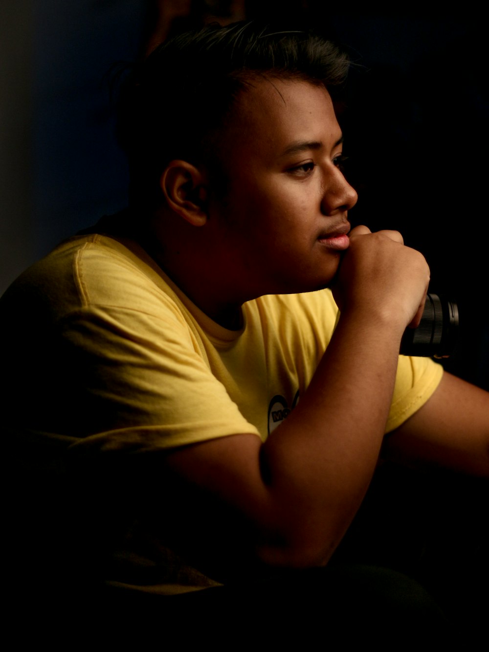 man wearing crew-neck shirt holding camera