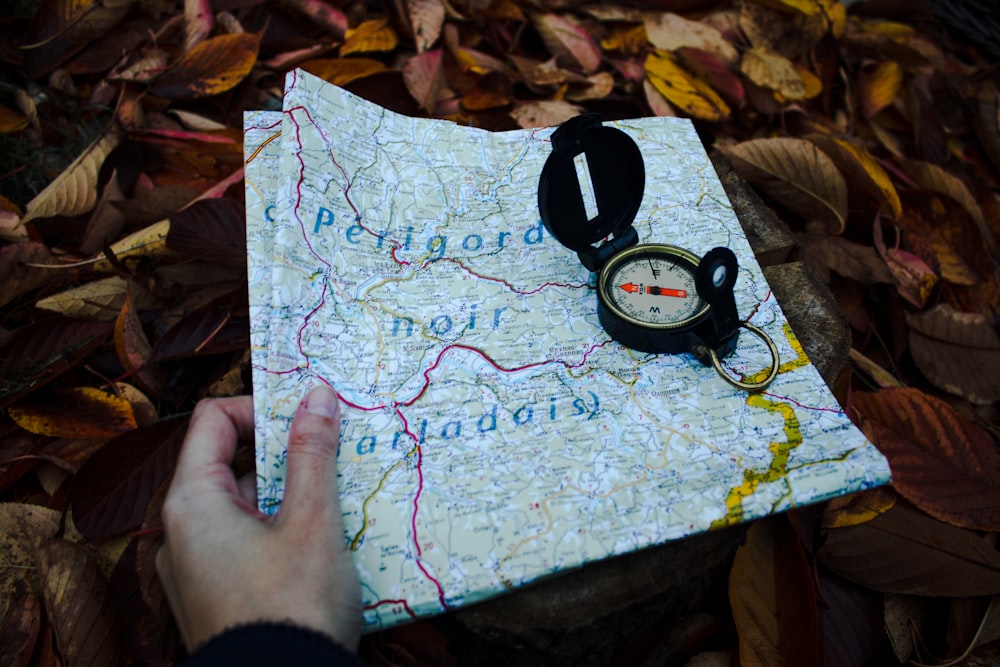 round black compass and white and blue map