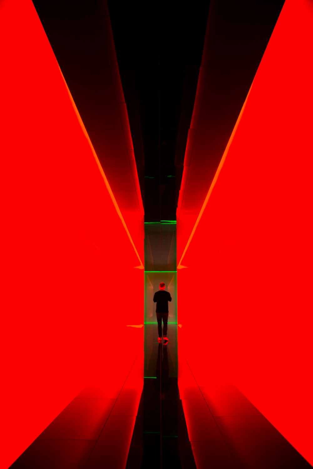 man between red light hallway