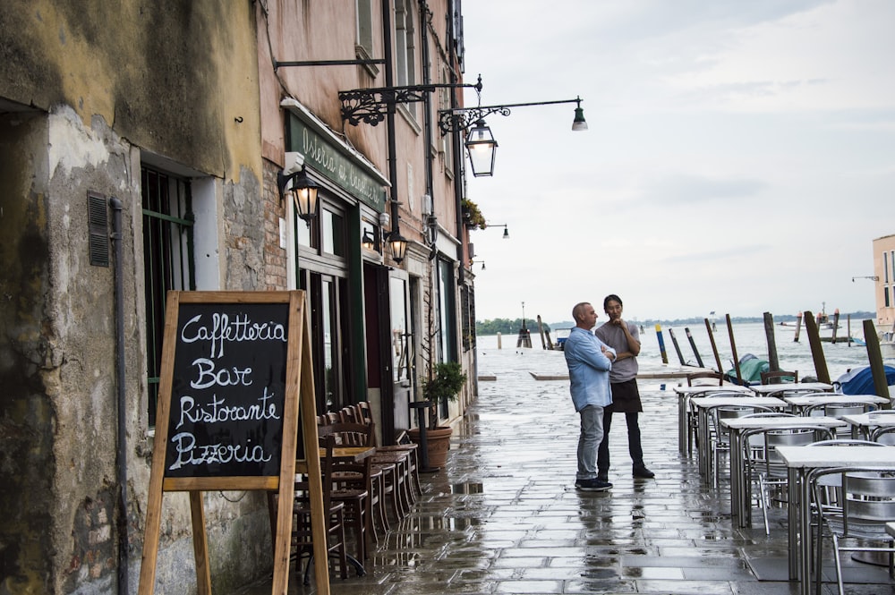 couple men standing outside near table