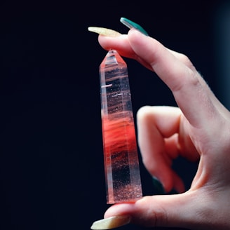 person holding red and black crystal