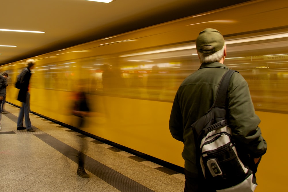 man standing in font of train