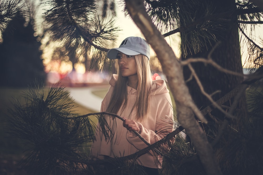 woman wearing white cap and pink hoodie