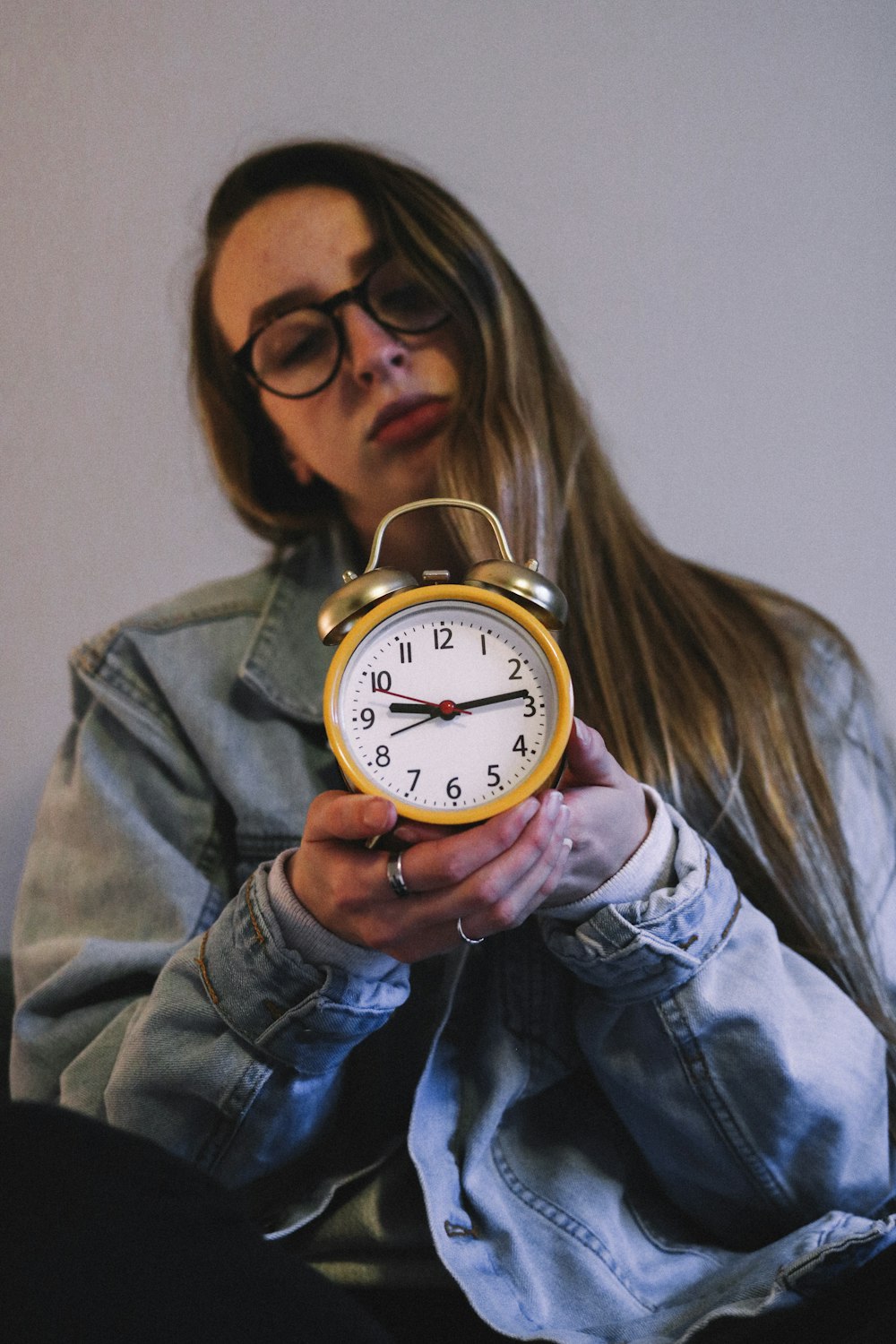 woman holding yellow alarm clock