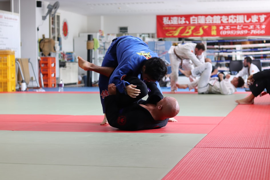 Two martial artists sparring inside a traditional dojo training hall
