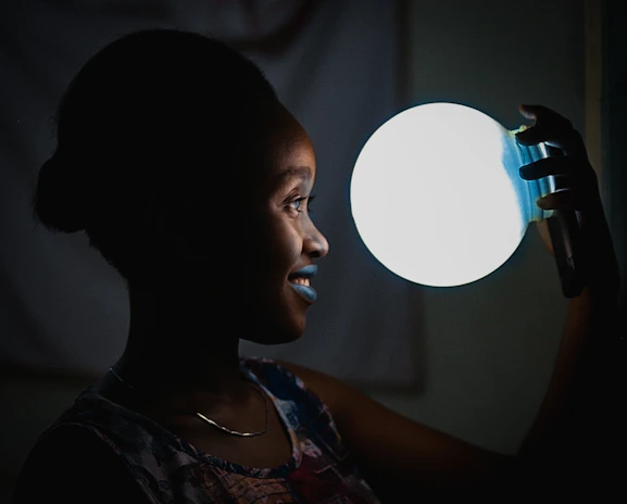 A happy customer holding a Tiverton emergency light with a bright smile.