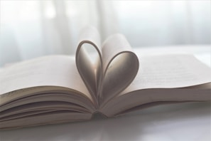 An open book with pages fluttering in the wind, symbolizing stories of love.