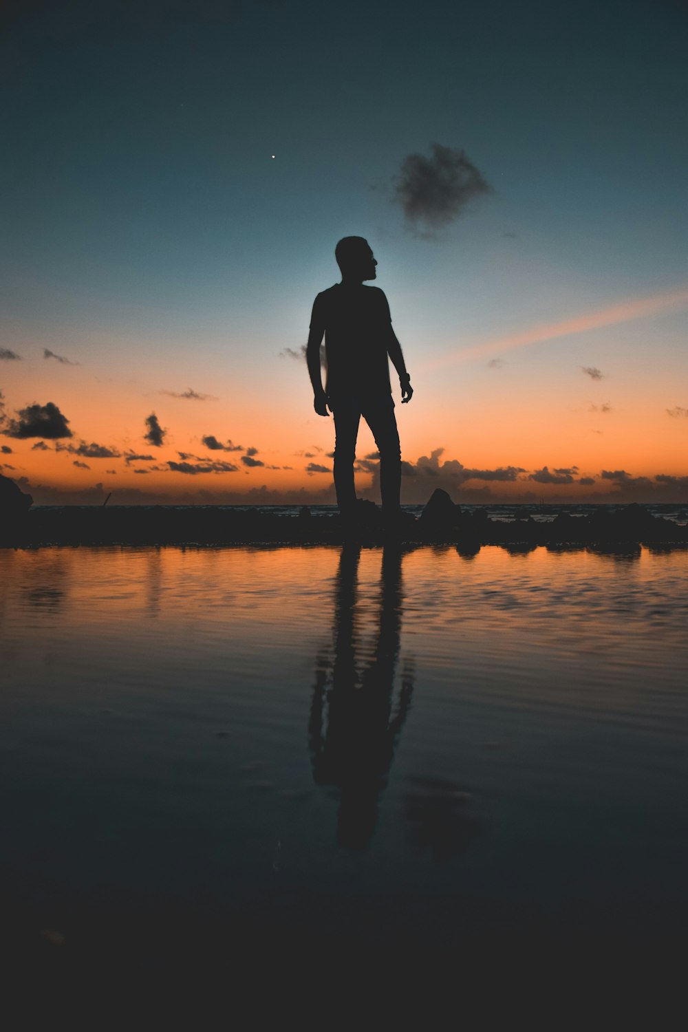 photo of man standing near body of water