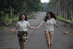 A joyful couple holding hands in a serene park.