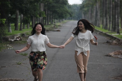 The couple walking hand in hand down a flower-lined path, glowing with happiness.