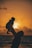 silhouette photo of man carrying baby during golden hour
