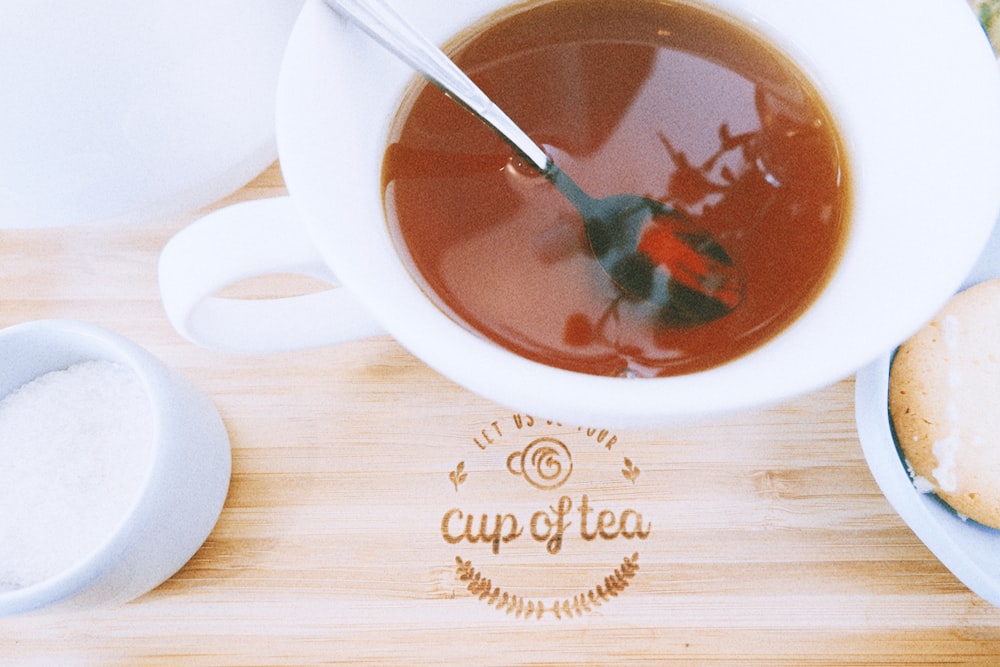 xícara de chá de cerâmica branca na xícara de madeira marrom da tábua de chá