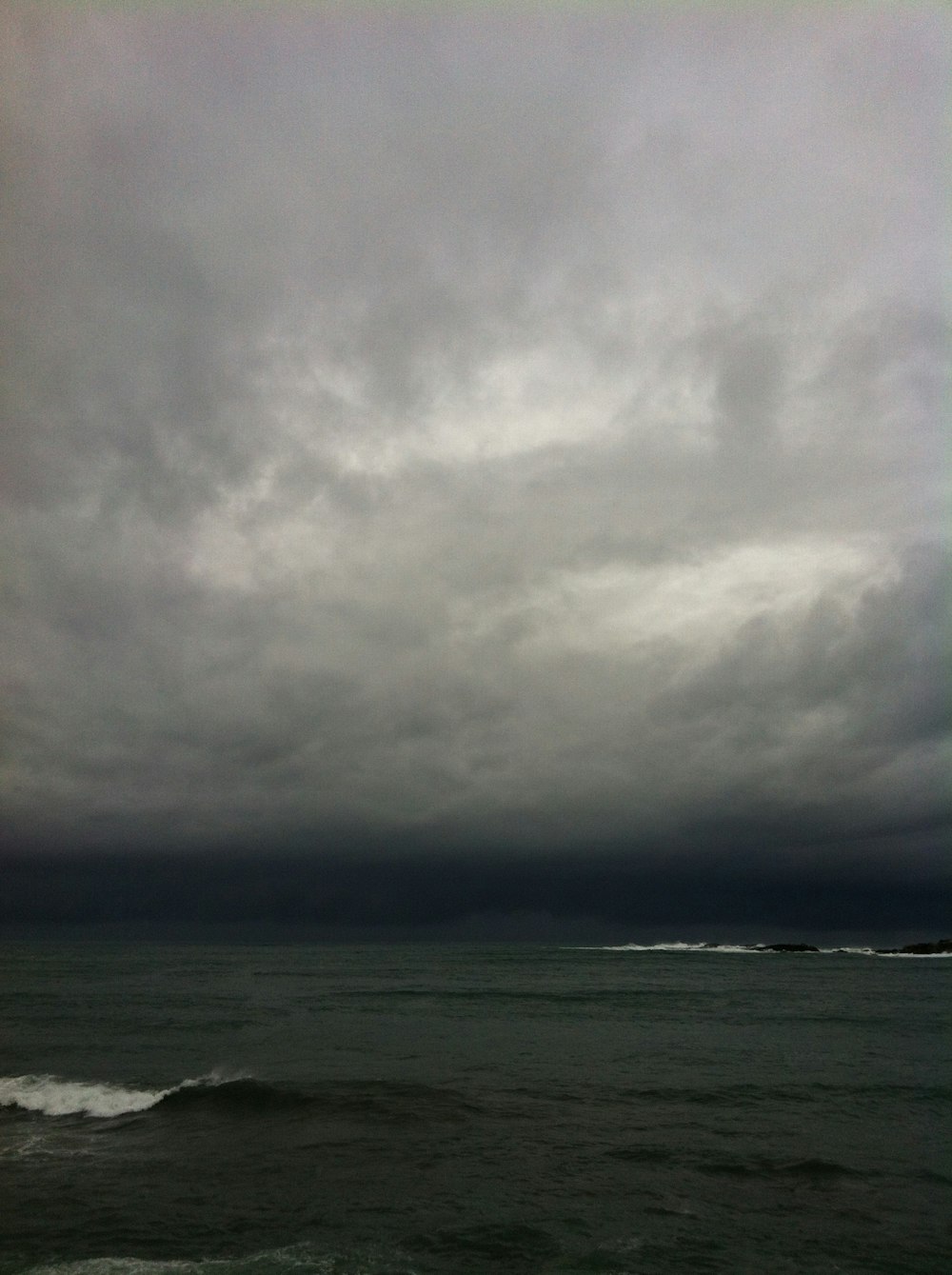 ocean waves under nimbus clouds