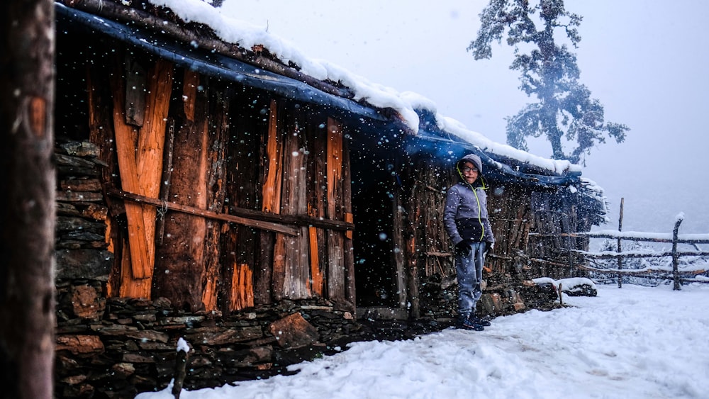 man standing in front of wooden house