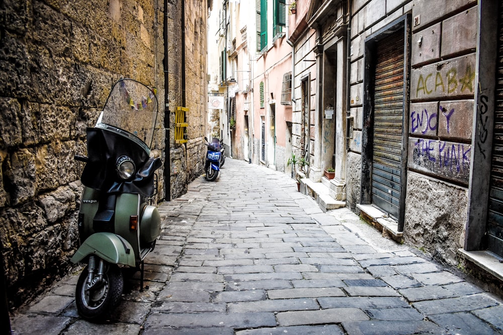 green motorcycle parked beside building