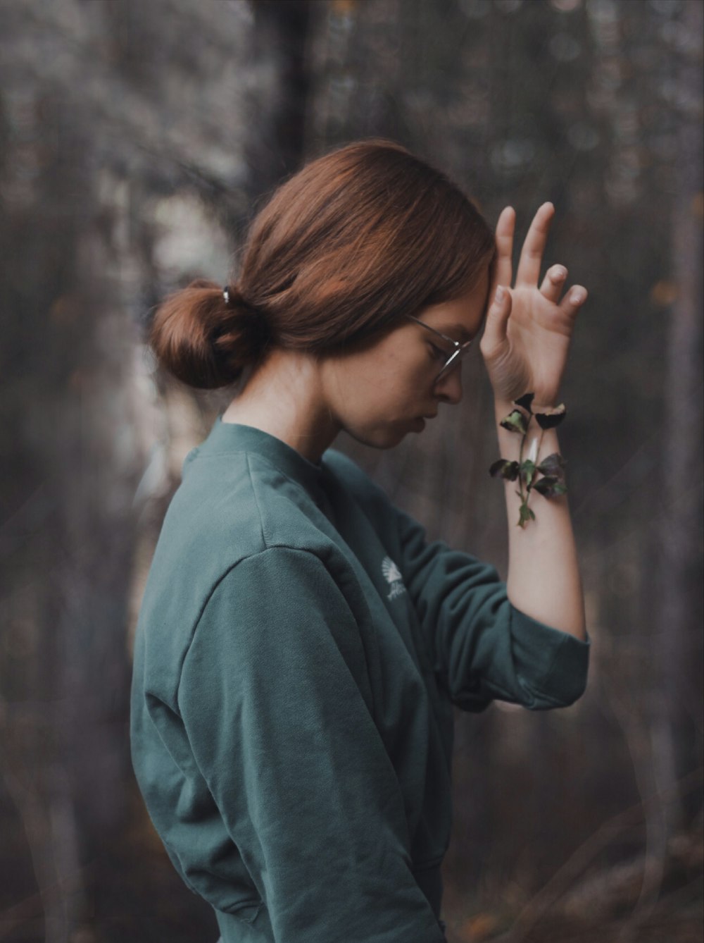 selective focus photography of woman wearing grey crew-neck 3/4-sleeved top in front of forest