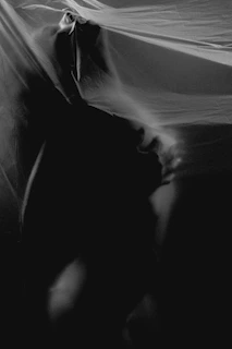 A wide-angle photograph capturing a conceptual fashion scene with minimalist styling and soft shadows.