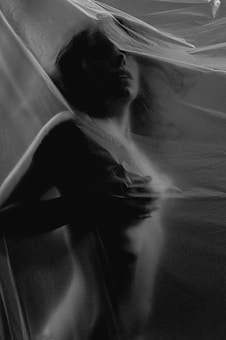 A silhouette of a person captured behind a translucent material, creating a shadowy, mysterious effect. The image is rendered in shades of black and white, enhancing the sense of privacy and abstraction.