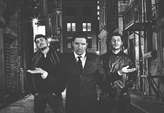 Three brothers standing proudly in front of their flour mill, symbolizing family and dedication.