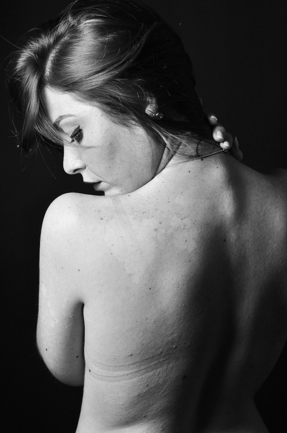Photo en niveaux de gris d’une femme aux seins nus