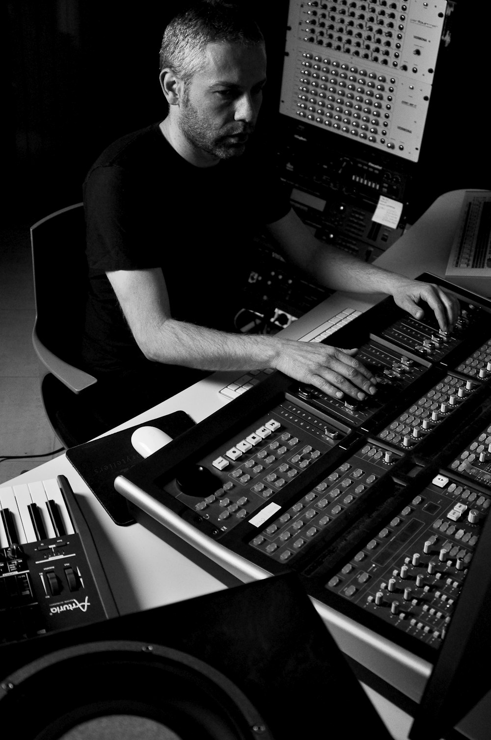 man using audio mixing console grayscale photo