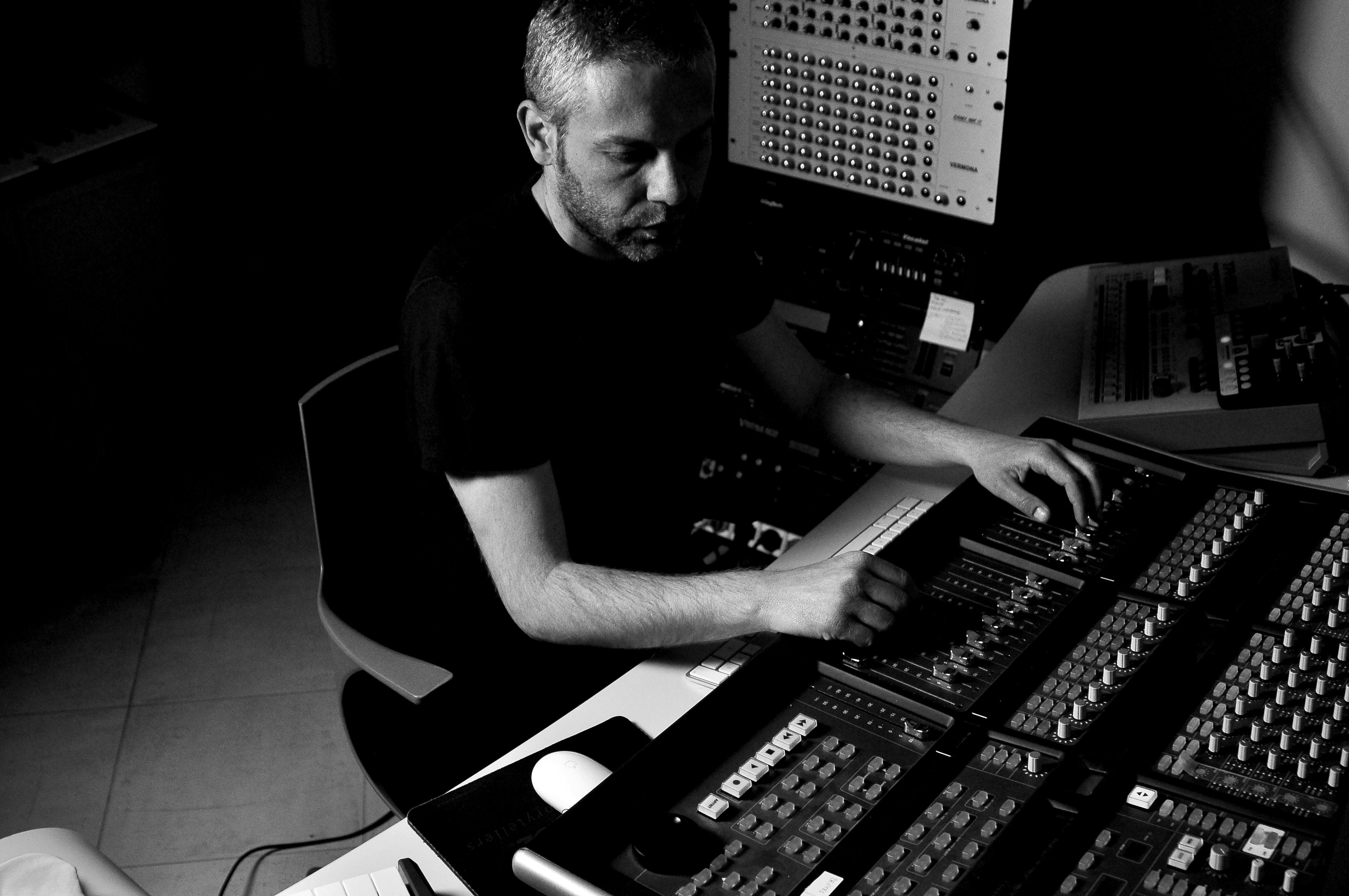 Person sitting at mixing console, mixing royalty free music