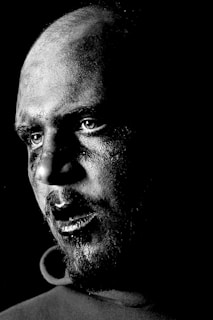 A dramatic black and white portrait of Juan Vargas directing a scene on set.