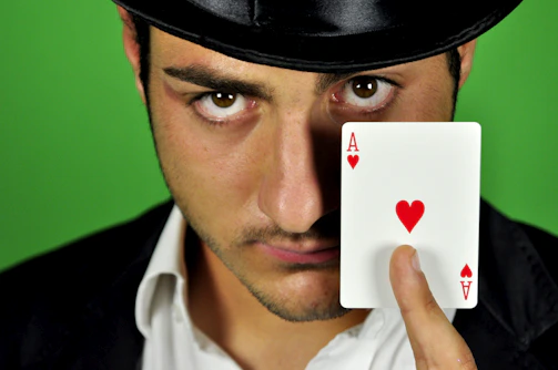 A close-up of a red hat magician performing a card trick at an elegant corporate event in Atlanta.