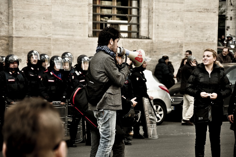 man holding megaphone front of woman