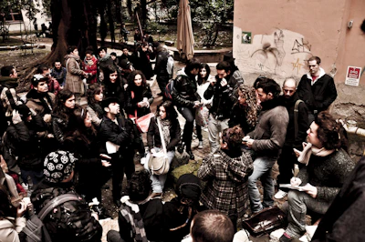 A group gathered outdoors sharing stories during a community event.