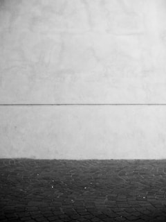 Minimalist styled black and white slide resting on a smooth stone surface with soft shadows.