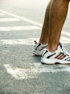 Close-up of a runner's feet pounding the pavement in vibrant red Sportshouse trainers.
