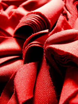 Deep burgundy wool fabric with a subtle weave pattern, folded elegantly.
