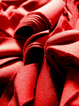 Glazed ceramics arranged elegantly on deep burgundy fabric with gentle reflections.