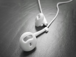 Stylish earbuds resting on a minimalist desk.