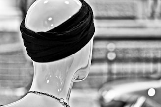 Close-up of a vibrant silk turban wrapped elegantly on a mannequin head.