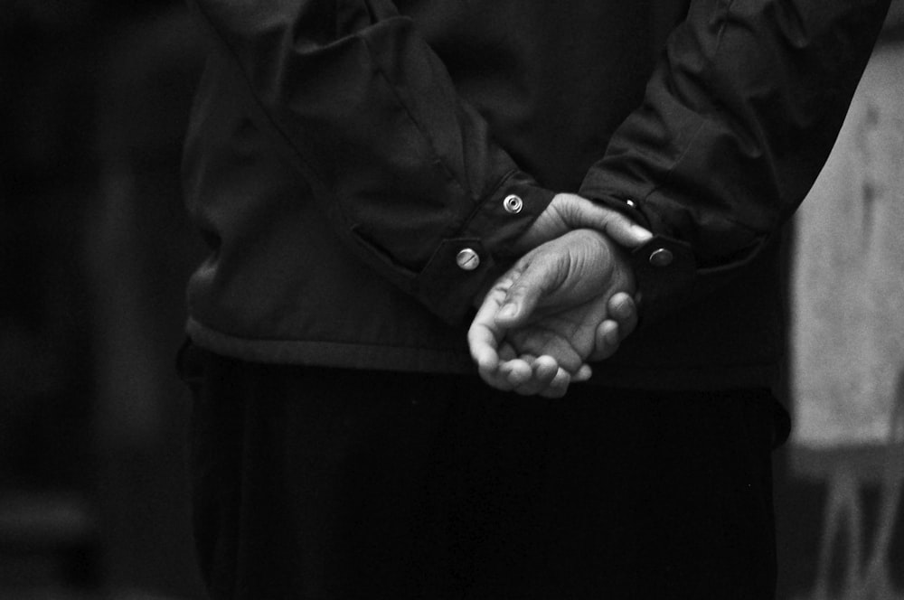 gray scale photo of holding hands