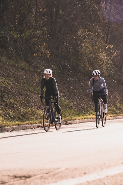Dois ciclistas de estrada subindo uma rampa respirando forte durante o esforço de resistência