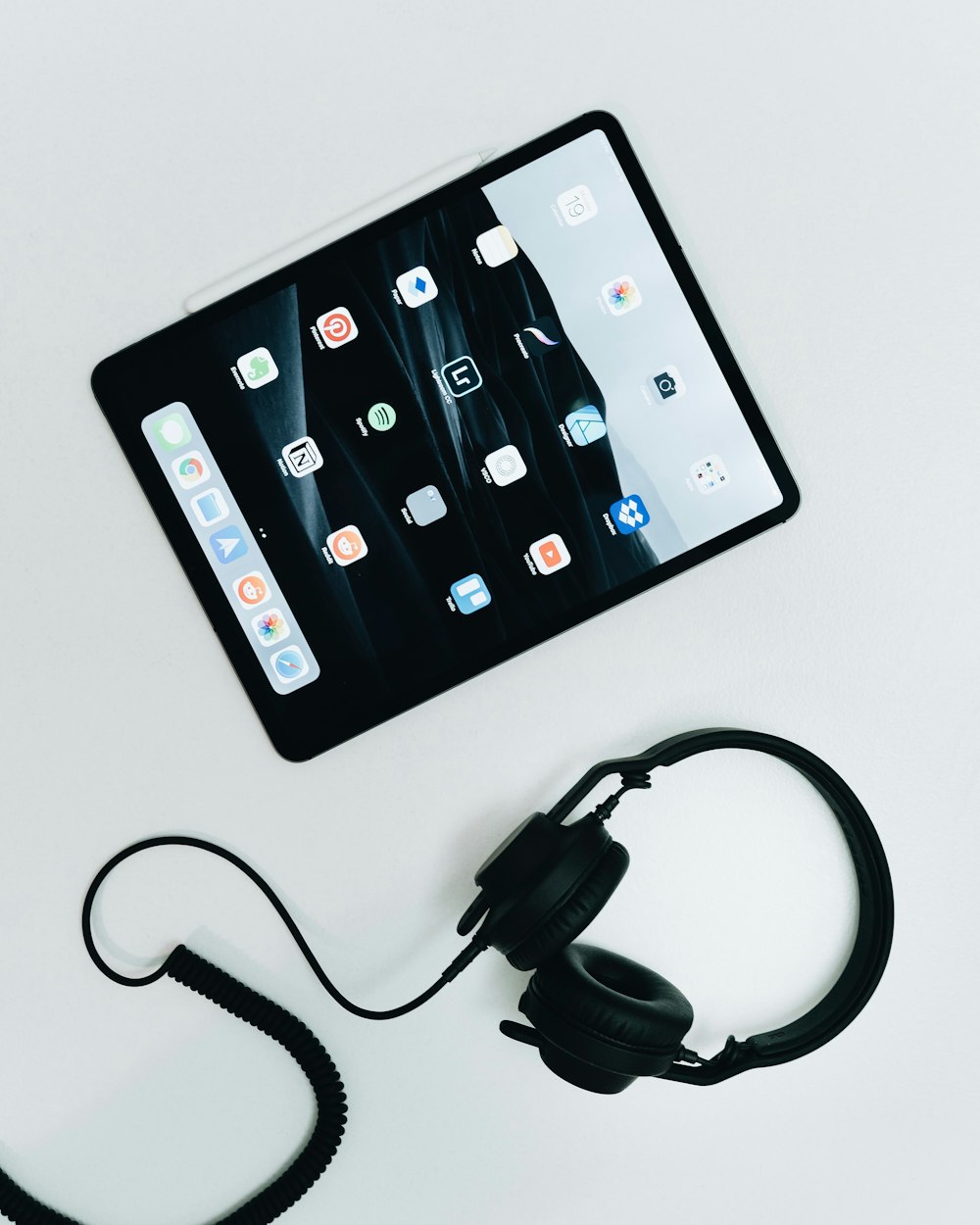 검은색 iPad 및 유선 헤드폰의 평평한 누워있는 사진