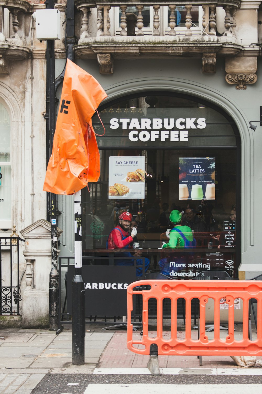 two men with Super Mario and Luigi costumes sitting inside Starbucks coffee cafe