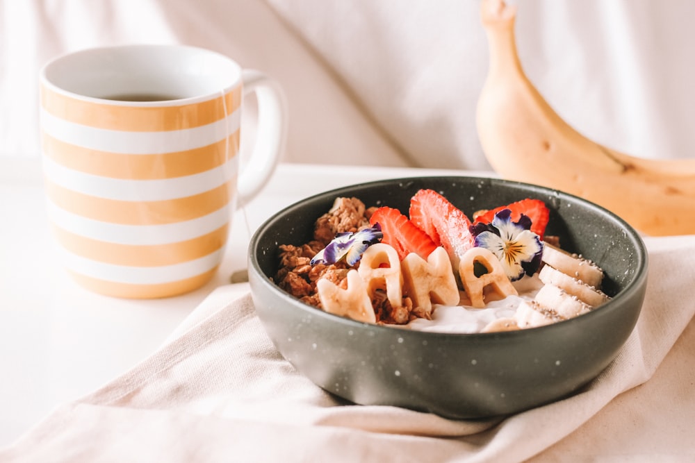 cooked food in bowl beside white mug