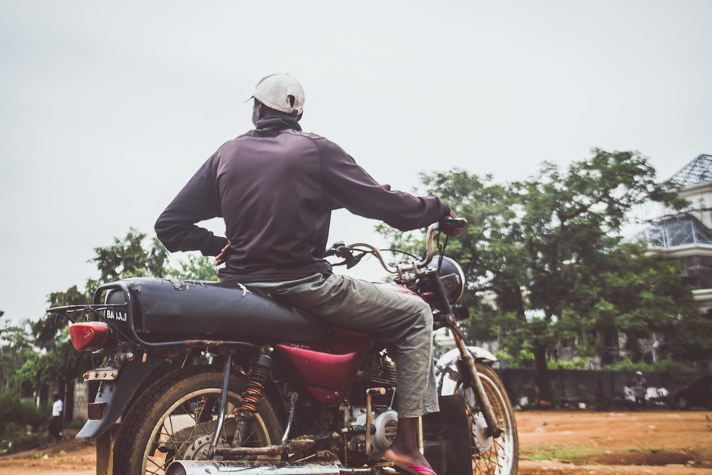 man riding black standard motorcycle