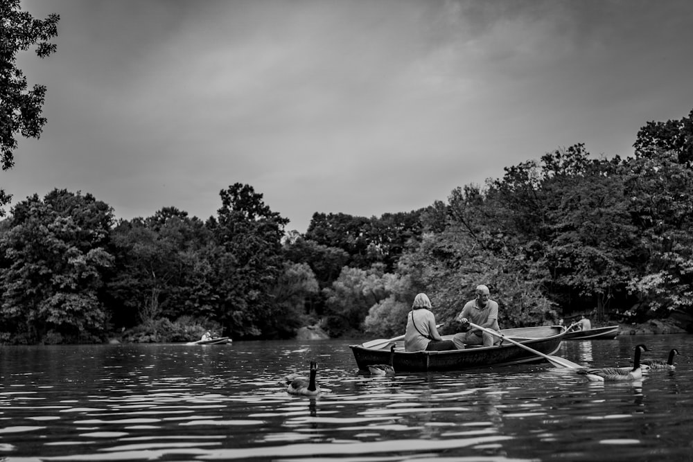 Graustufenfotografie von Frau und Mann auf einem Boot