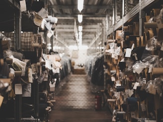 Warehouse workers inspecting denim fabric rolls before packaging.