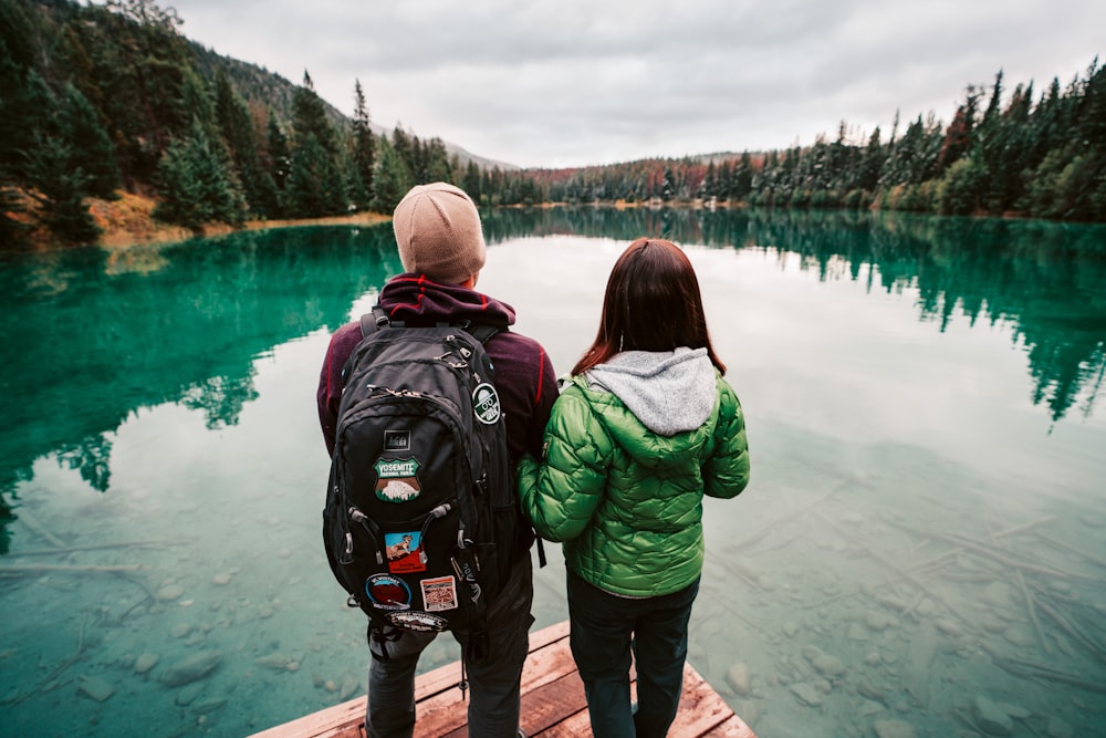 man and woman standing near body of water